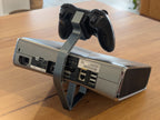 Silver Xbox 360 console and controller on a 3D printed display stand, rear view