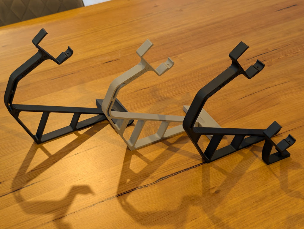 Three 3D printed Xbox 360 display stands in black and gray